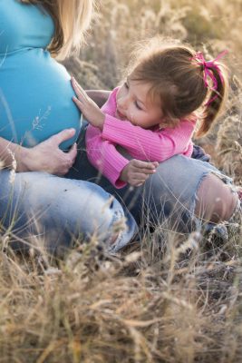 Child touching pregnant mother's stomach belly