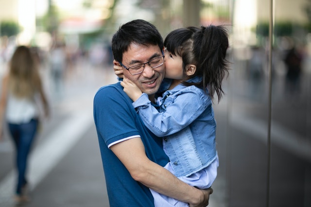 daughter kissing father